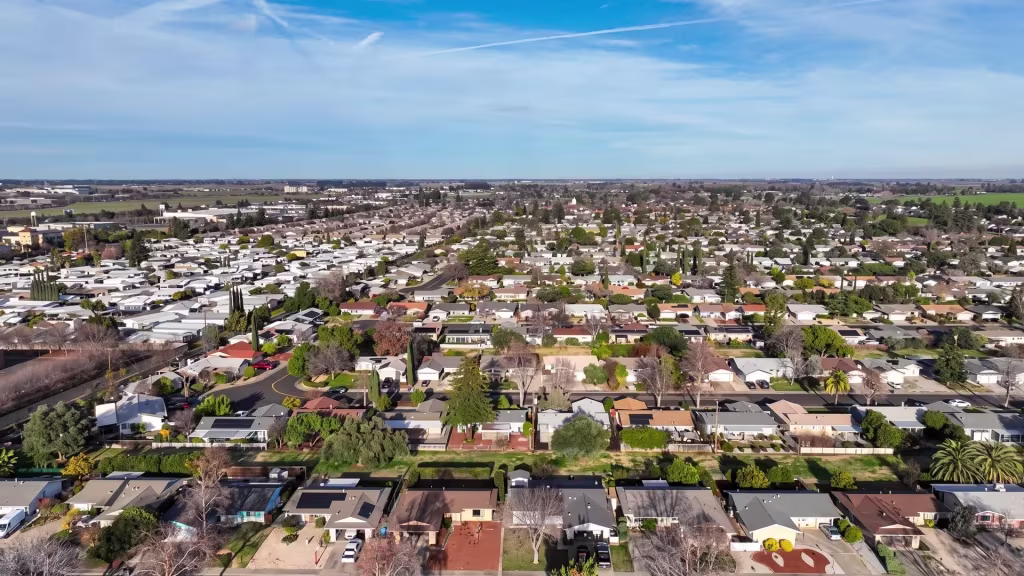 A broad low-rise city and residential grid spread beneath low sloping terrain in this panorama of Vacaville