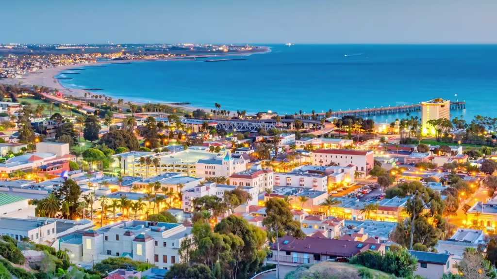 Ventura's coastal shoreline stretches beneath a twilight sky, seen from an elevated scenic overlook