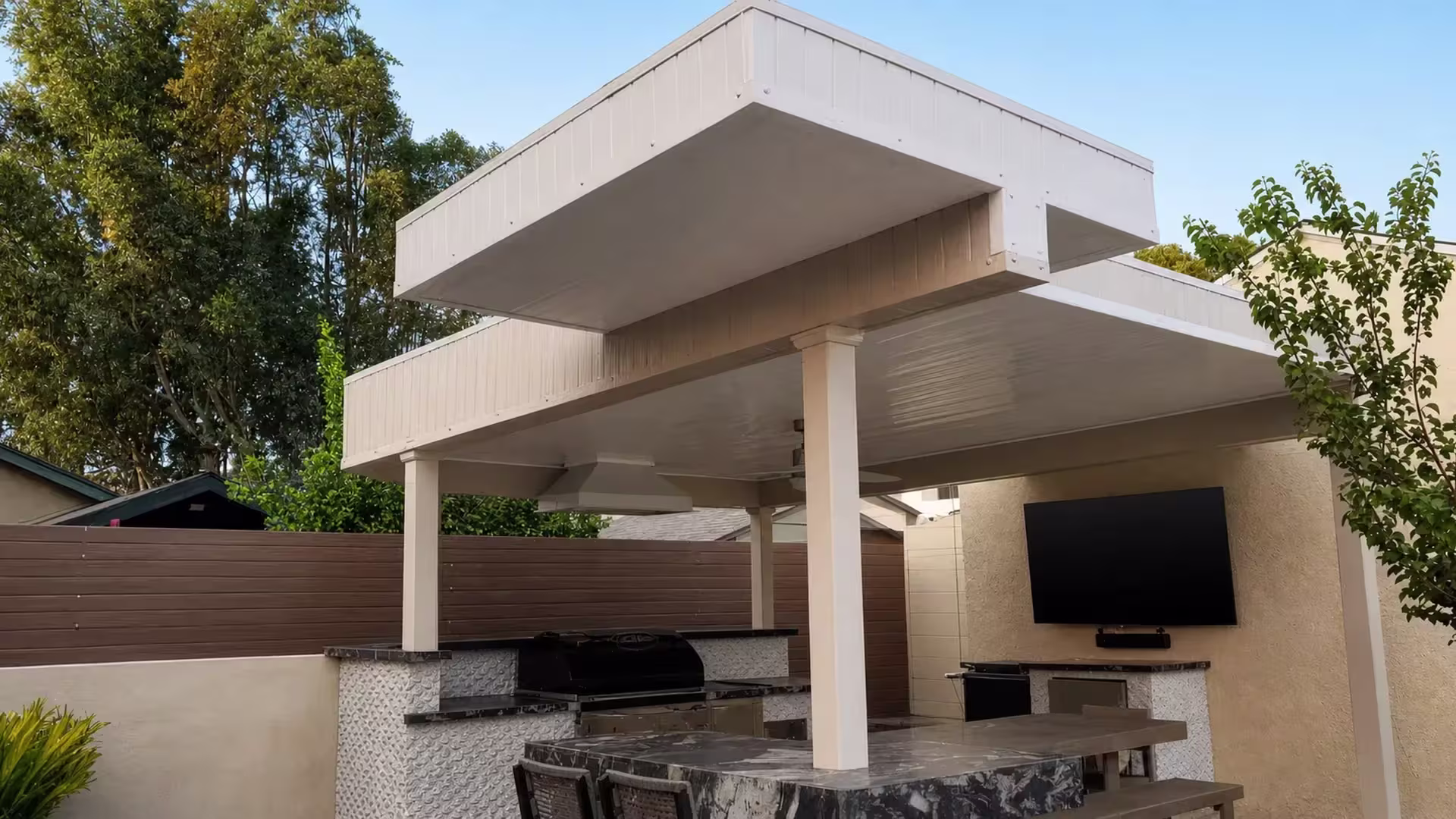 Tan vinyl custom patio cover with a deep box fascia canopy above a masonry outdoor bar