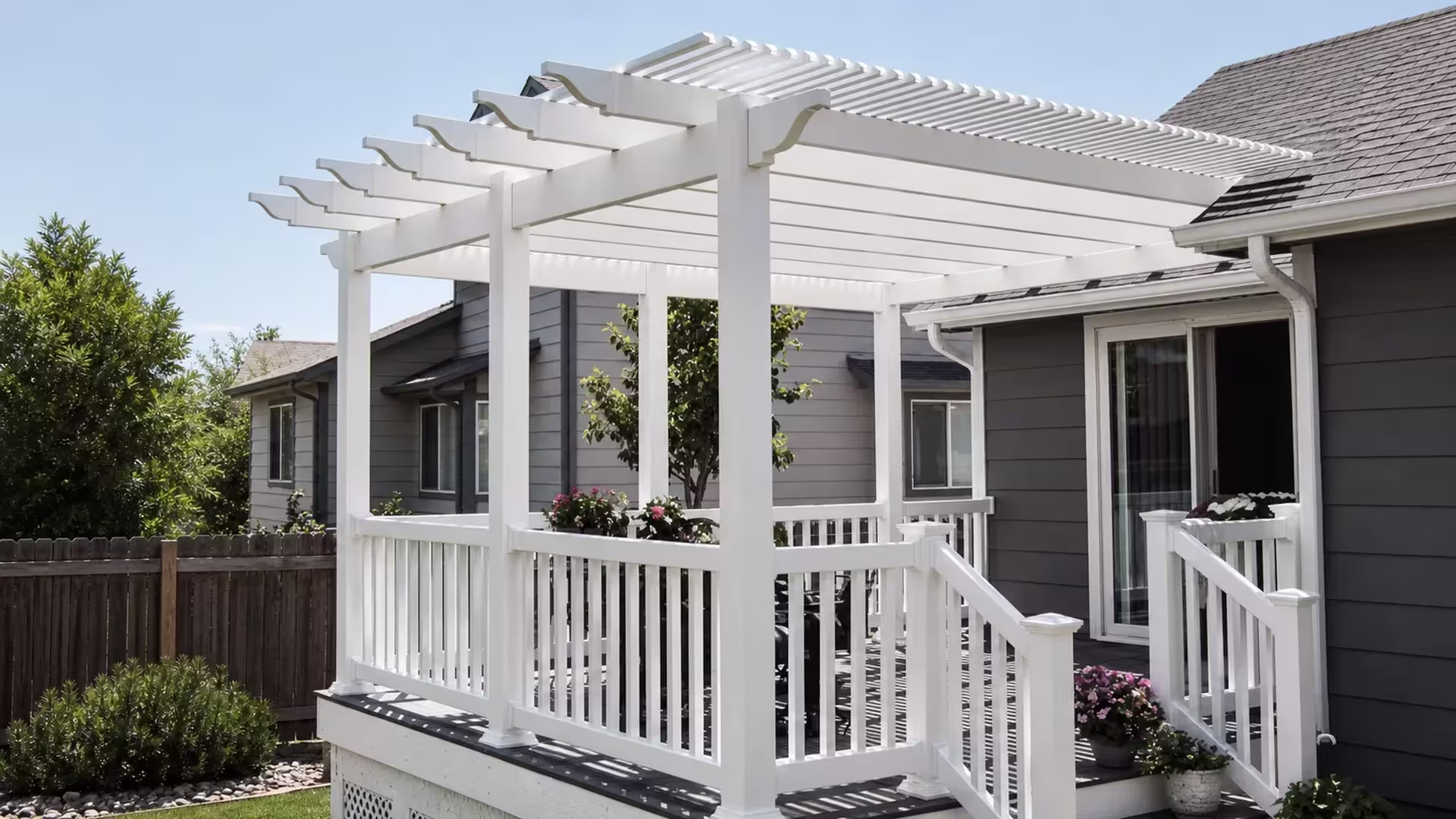 An open-lattice roof, custom fitted, tops this White vinyl patio cover integrated with a raised deck and picket guardrail