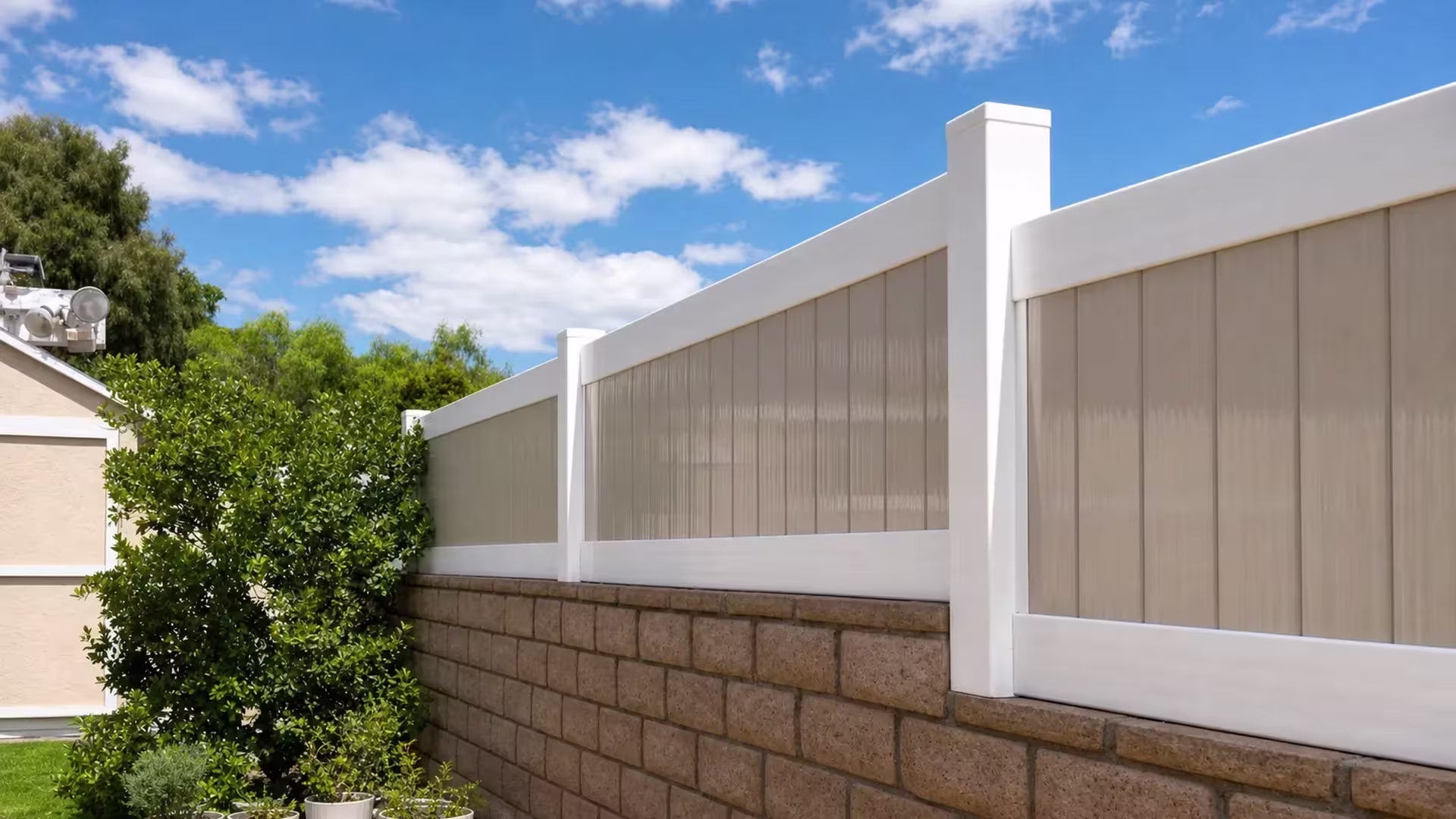 Tan custom vinyl wall topper with translucent acrylic panels following the slope of a masonry retaining wall