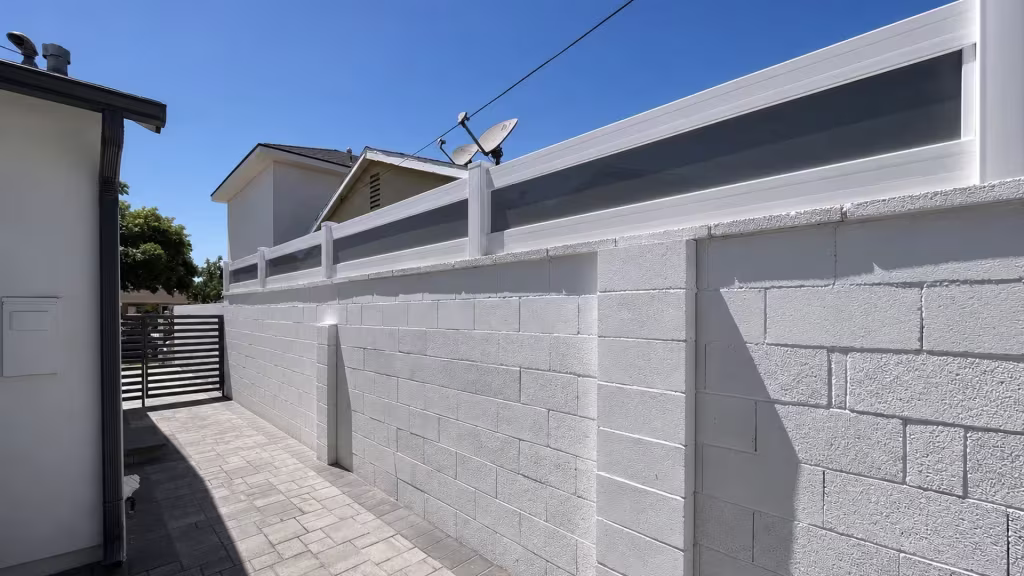 White custom vinyl wall topper with smoke gray translucent infill stepping down a painted concrete block wall