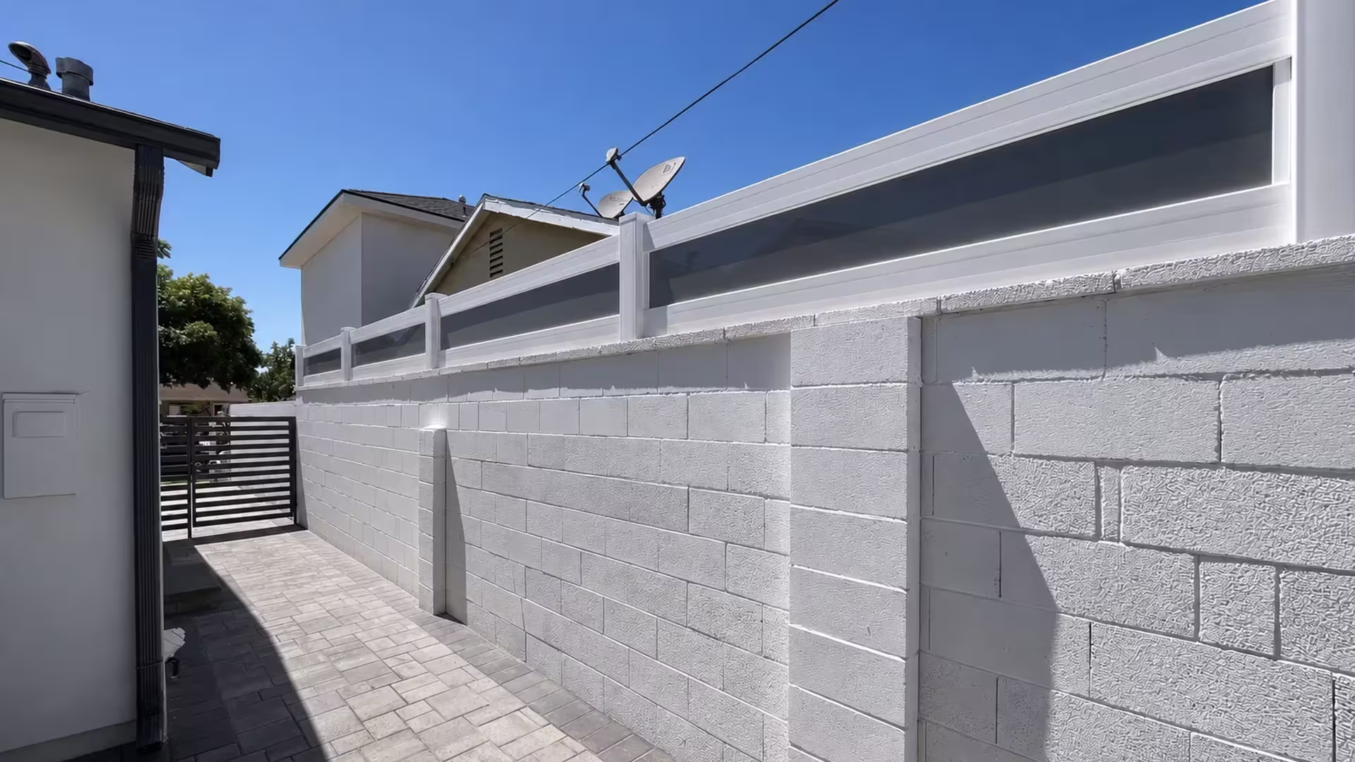 White custom vinyl wall topper with smoke gray translucent infill stepping down a painted concrete block wall