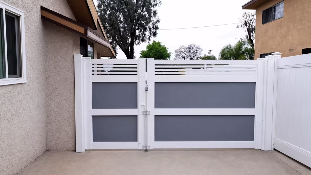 Stacked gray acrylic inset panels sit beneath the horizontal slats of this White vinyl driveway gate