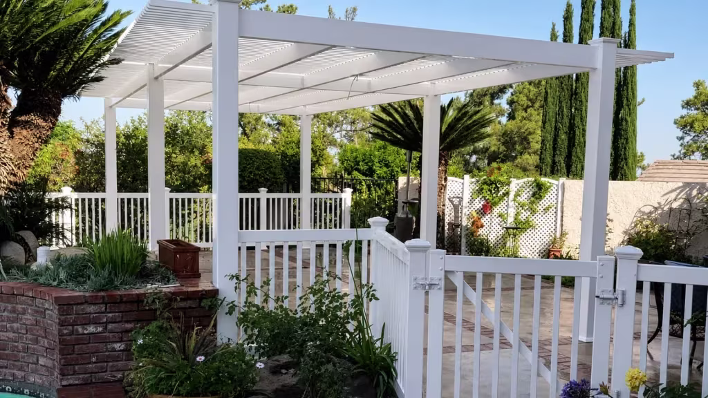 Open lattice White vinyl freestanding patio cover set beside brick planters at the pool edge