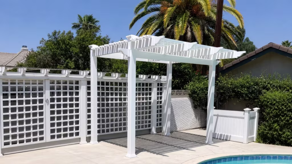 Open sided White vinyl freestanding patio cover stands beside a swimming pool and a utility pole