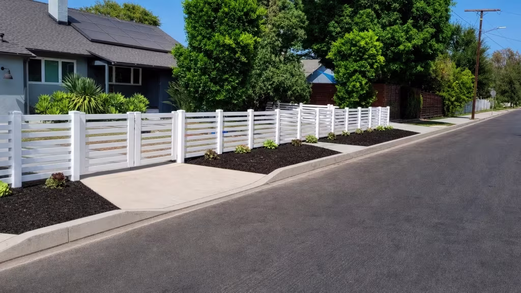 Long White vinyl picket fence spanning the frontage beneath a roofline lined with solar panels