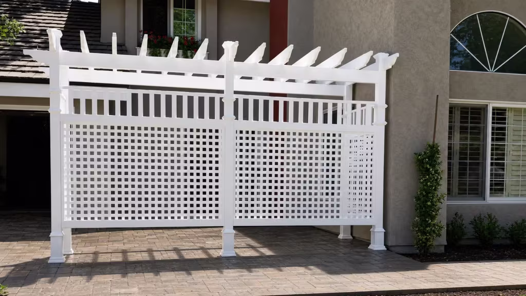 A lattice side screen on a White vinyl pergola runs along the house facade and its planting beds