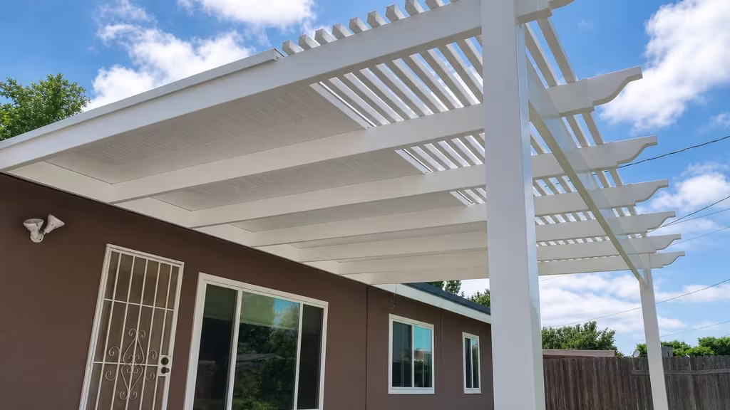 Solid roof panels give way to open slats along this White vinyl picket patio cover on a brown house