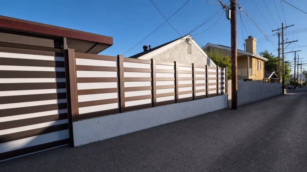 Dark Walnut vinyl privacy fence with acrylic mounted along a white painted concrete block wall