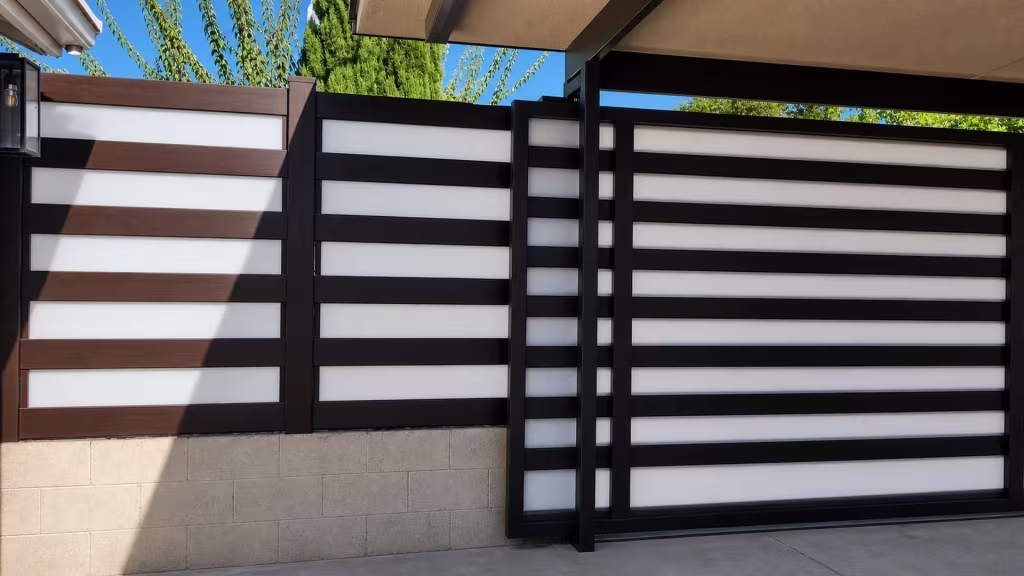 Carport roofline shelters this Dark Walnut vinyl privacy fence with alternating acrylic bands