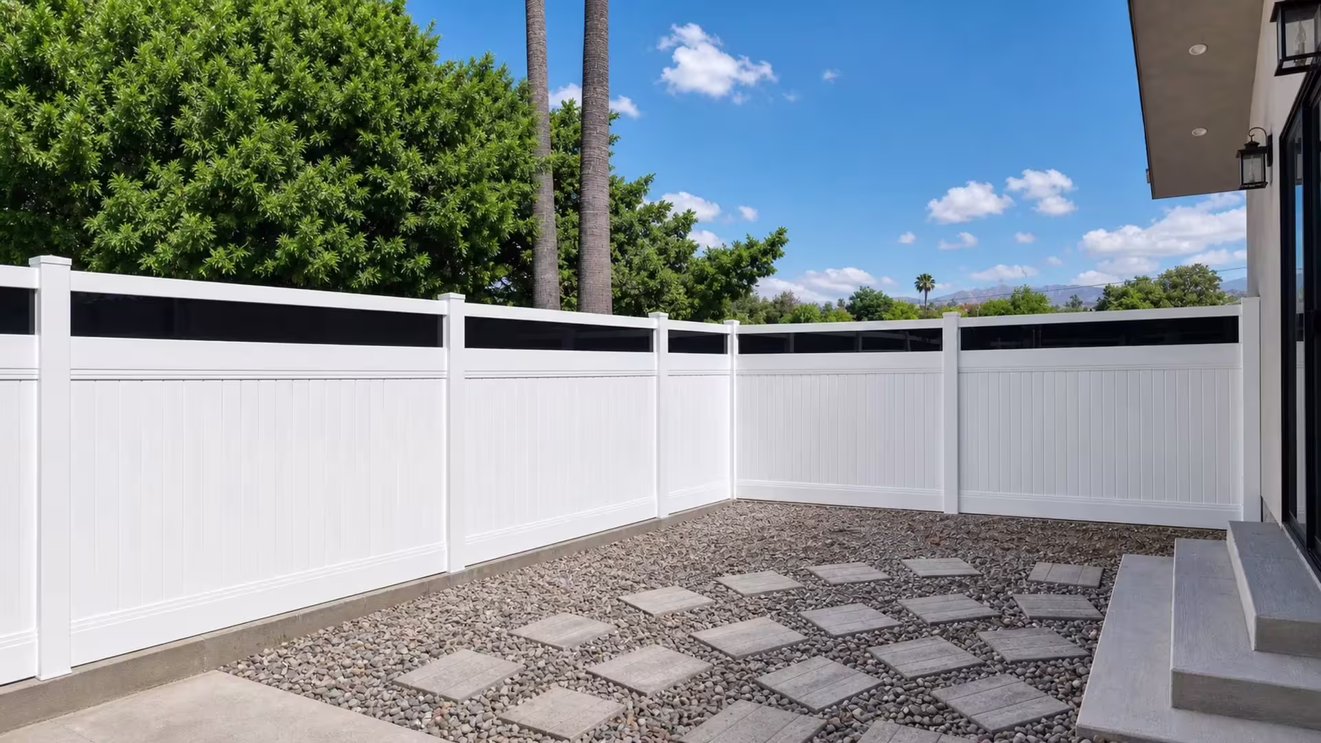 White vinyl privacy fence with acrylic lines five bays past concrete steps beneath palms and distant mountains
