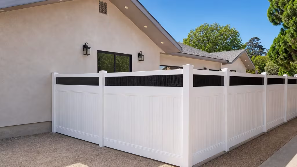 White vinyl privacy fence with acrylic wraps a right angle corner around the house-side yard in five bays