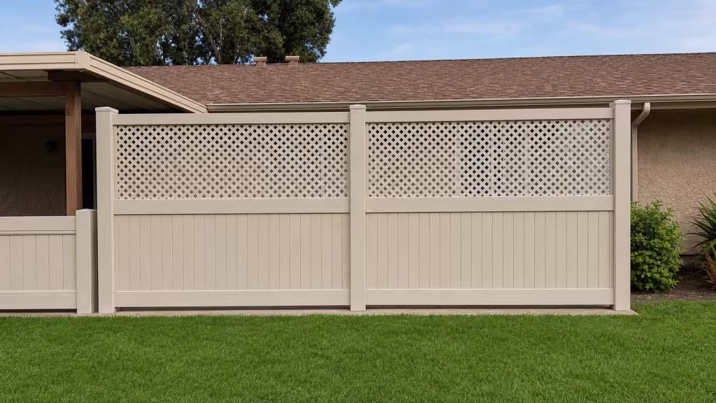 Two broad bays of Tan vinyl fence with lattice topped rails sit beside a patio cover and stucco eaves