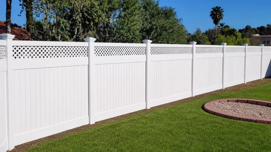 A curved gravel planting bed borders a lattice crowned White vinyl privacy fence near seven capped posts