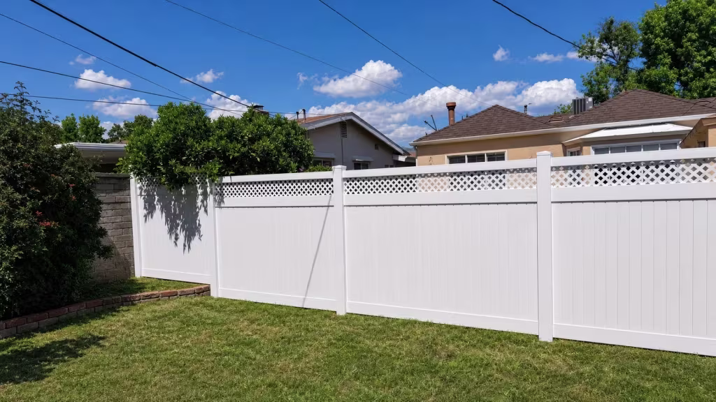 Overhead utility lines cross above four spanning panels of White vinyl fence finished with a lattice top