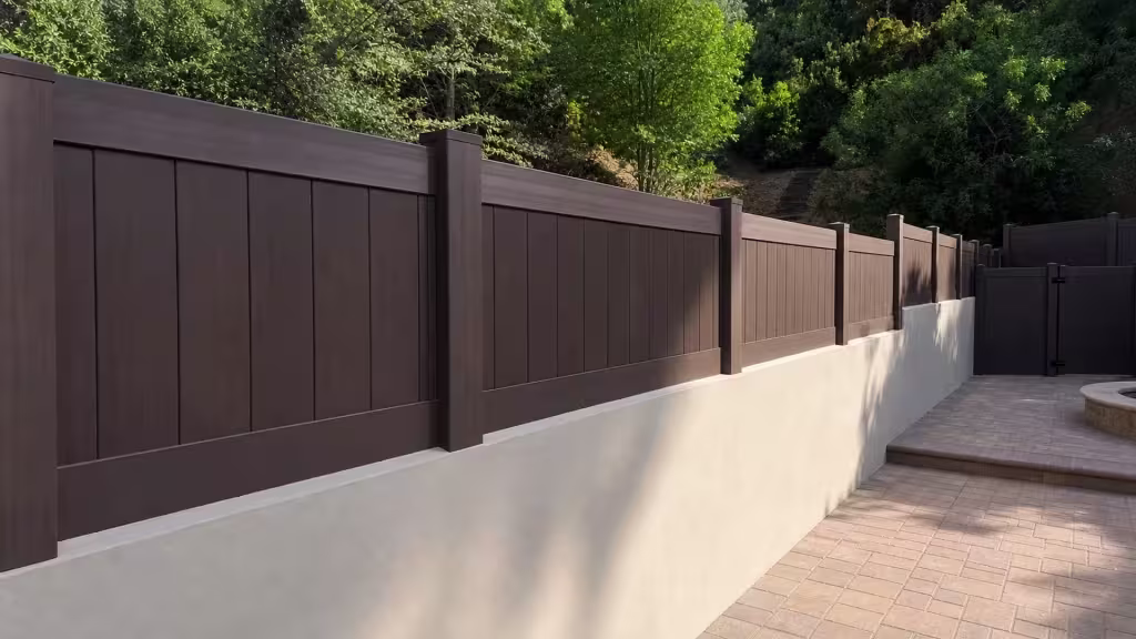 Stepped Dark Walnut vinyl wall topper follows the sloped grade of a cream stucco wall toward a matching gate return