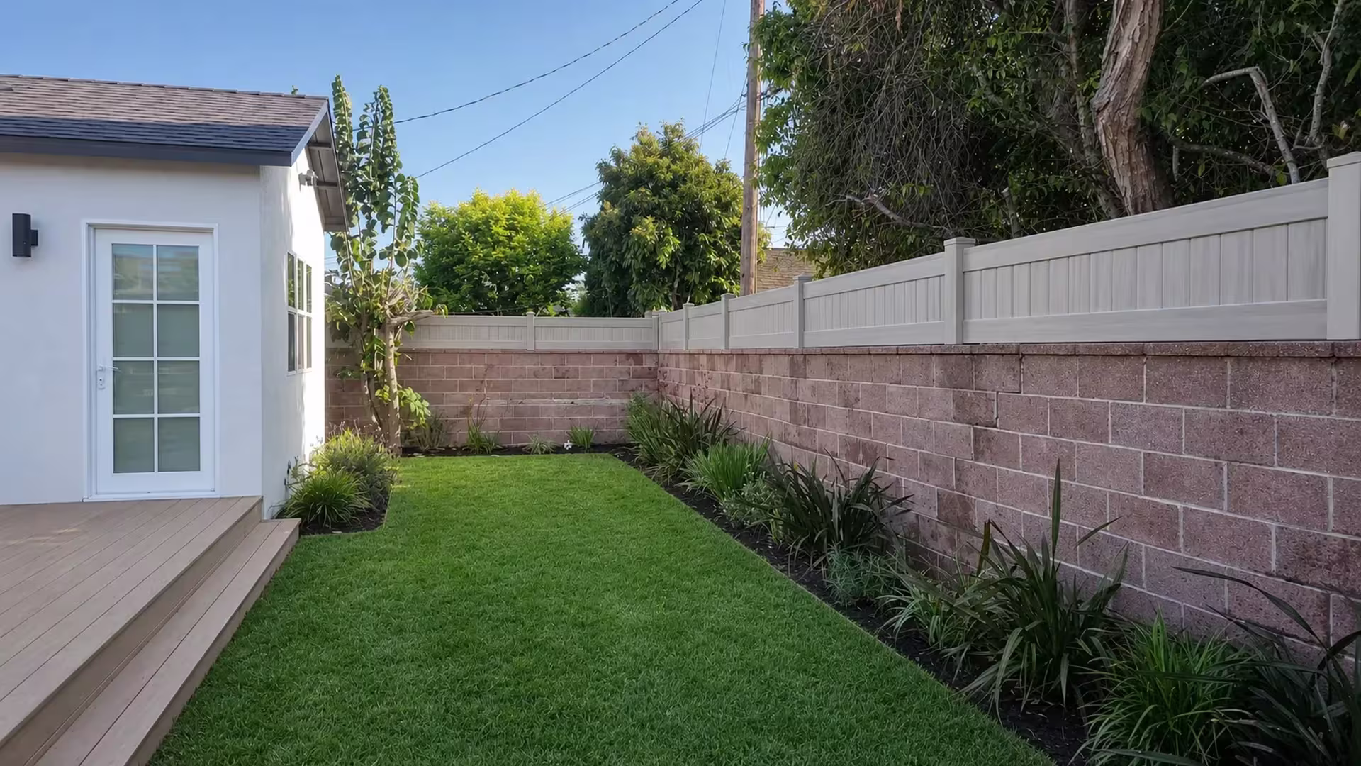 Mesquite vinyl topper wraps a corner on a pinkish red block wall near the house deck and steps