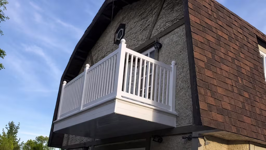 Four ball capped posts anchor White vinyl balcony railing that wraps one outside corner of the upper level
