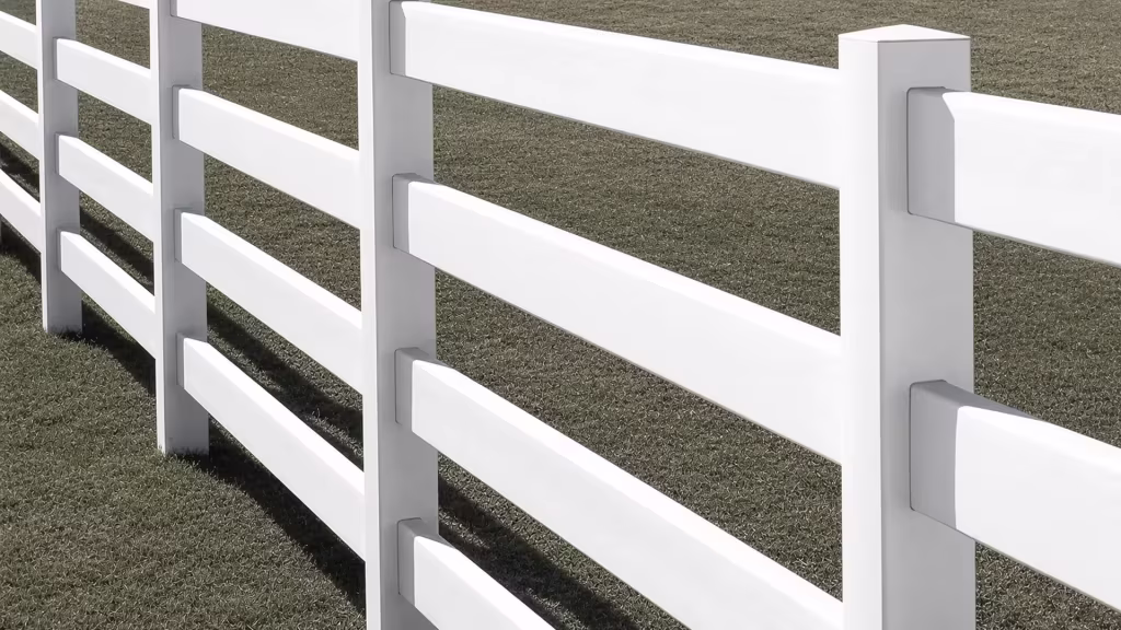 Faceted pyramid caps sit above open gaps between four White vinyl rails on this ranch fence