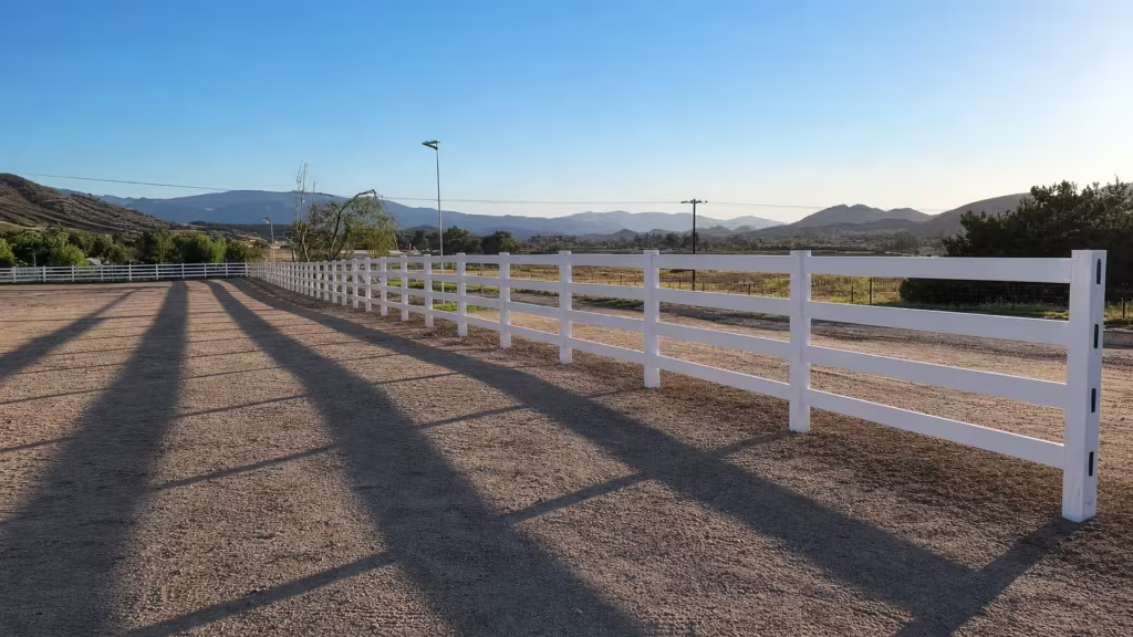 Four horizontal rails repeat at even spacing along this straight White vinyl ranch fence run