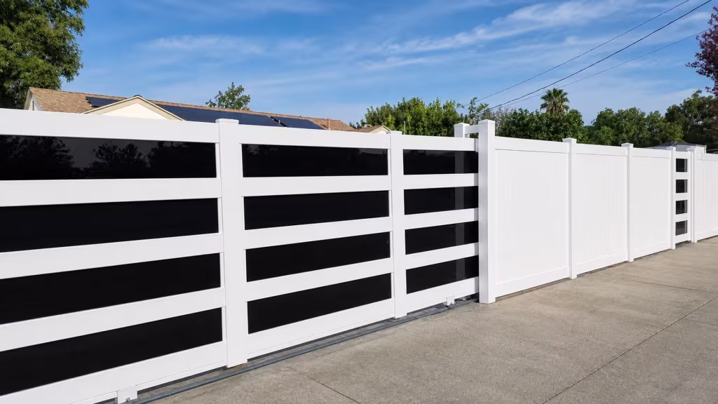 Five dark glossy acrylic bands frame this White vinyl rolling gate, sliding beneath a rooftop fitted with solar panels