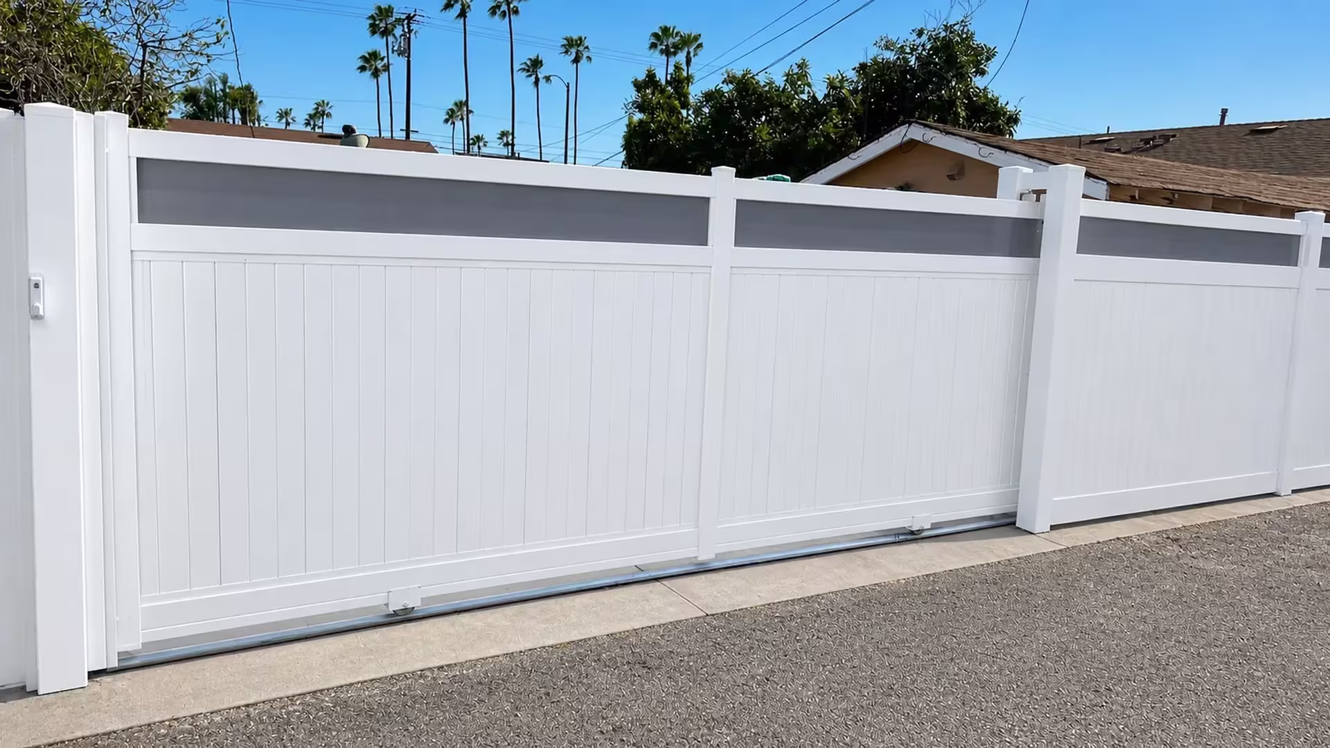 Tongue-and-groove boards pair with a dark, translucent-look horizontal band on this White vinyl rolling gate
