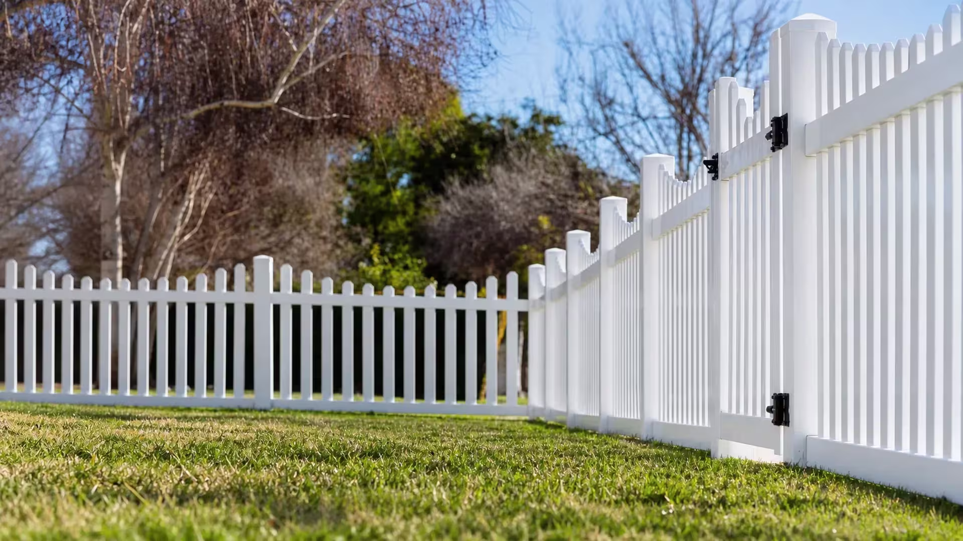 White vinyl scalloped picket fence with a long right hand run and a perpendicular rear return