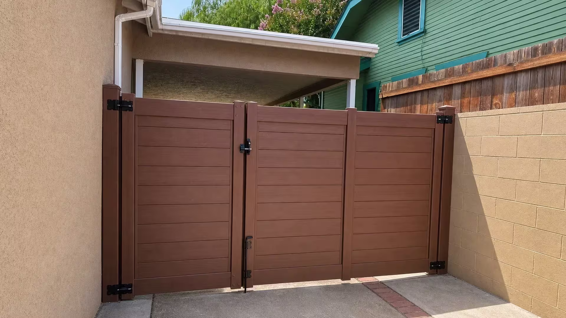 Brazilian Blend vinyl side gate closing a narrow side-yard opening between a stucco wall and a block wall