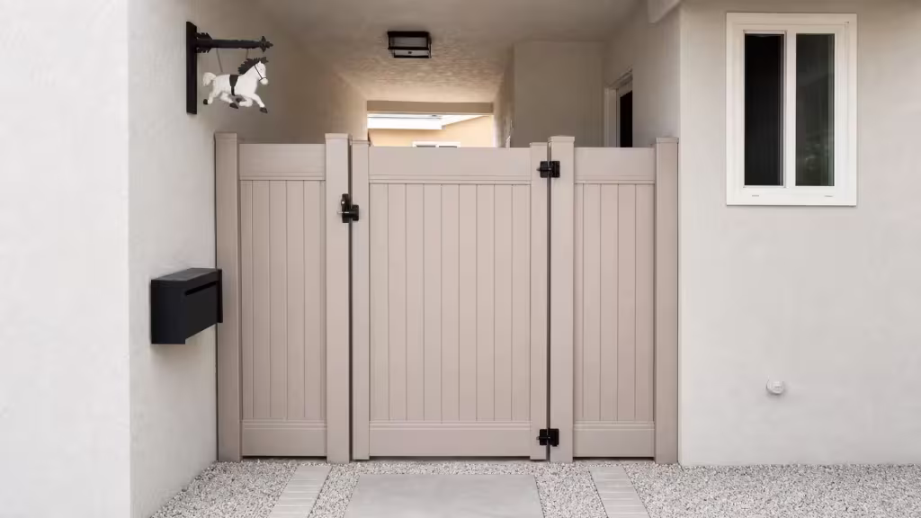 Clay vinyl side gate set across a covered stucco passage with a gravel and paver floor