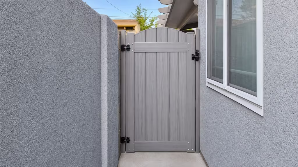 Coastal Cedar vinyl side gate fitted into a narrow passage between a masonry wall and a stucco house