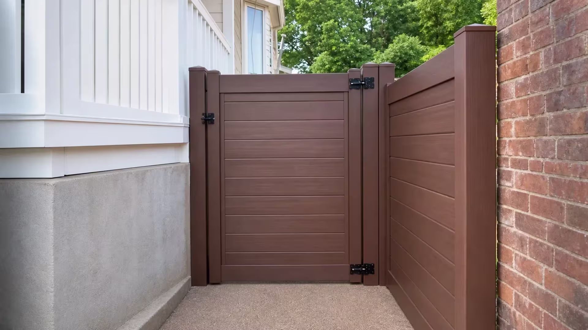 A narrow passage beside a brick wall holds this Dark Walnut vinyl gate with horizontal privacy boards