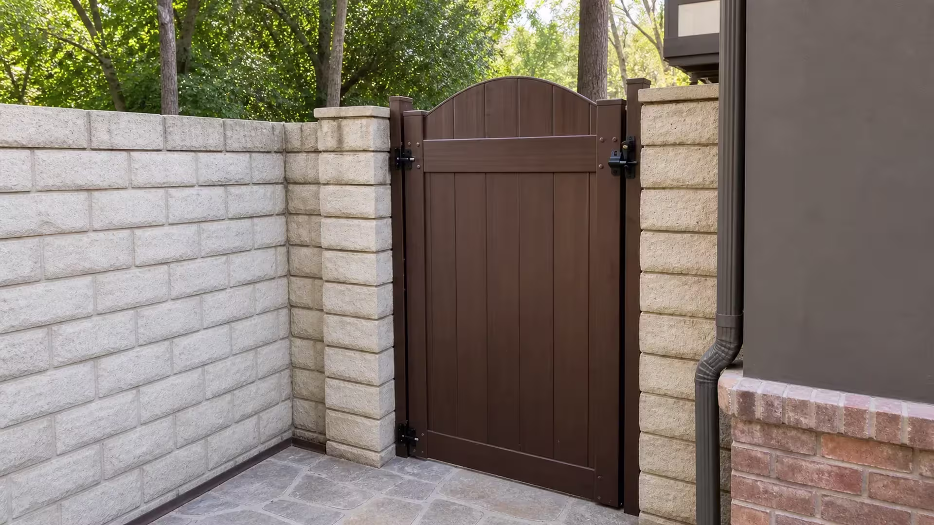 Two masonry columns frame a Dark Walnut vinyl side gate topped with a shallow center arch