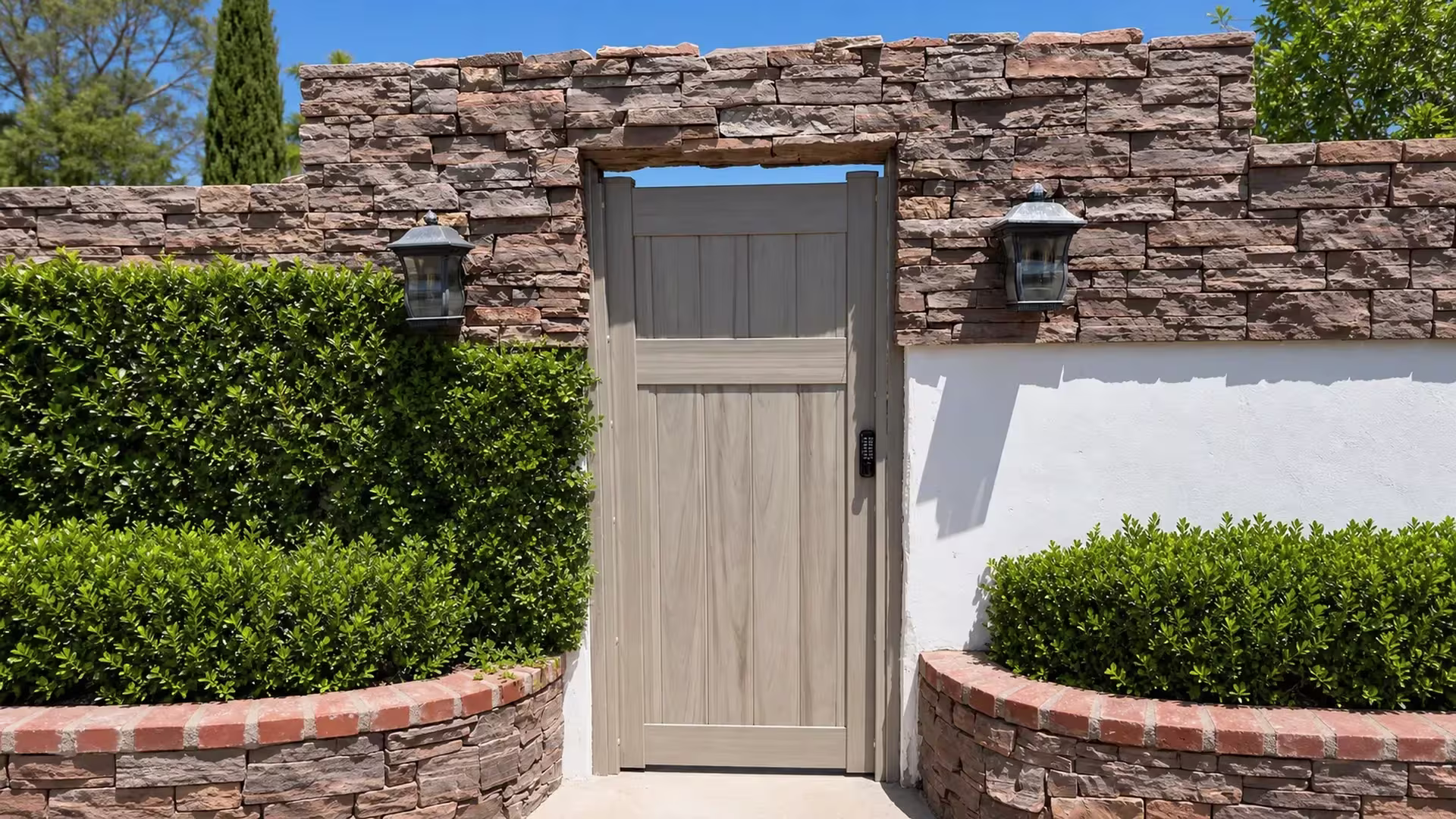 Mesquite vinyl side gate fitted within a stacked-stone and white stucco masonry opening