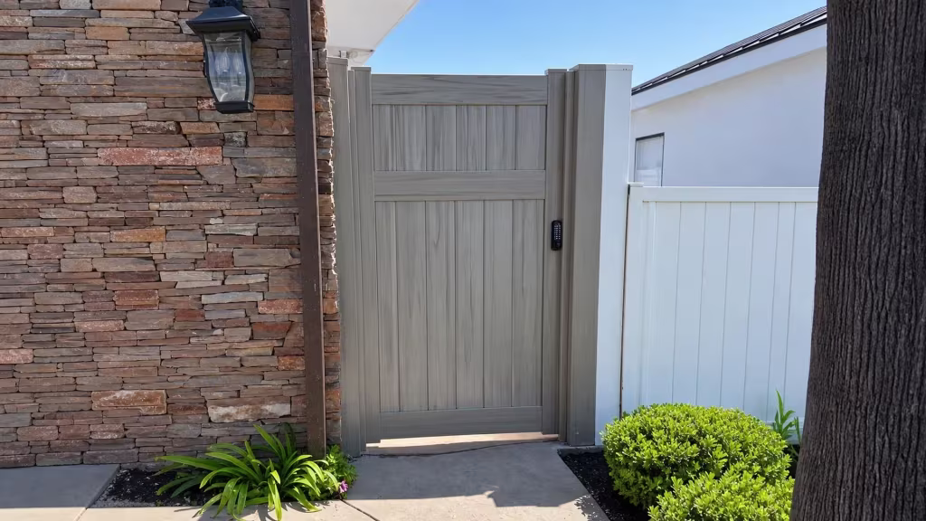 A stacked-stone pillar and mounted black lantern flank this Mesquite vinyl side gate at the walkway