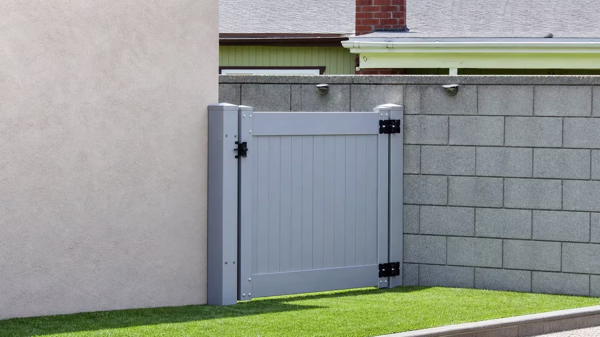 Slate Gray vinyl side gate installed near a chimney-topped roofline and a pair of mounted wall lights
