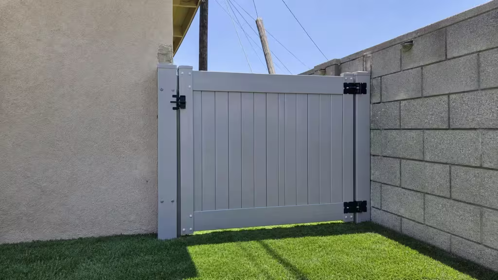 Slate Gray vinyl side gate closing a side yard beneath a utility pole and overhead wires
