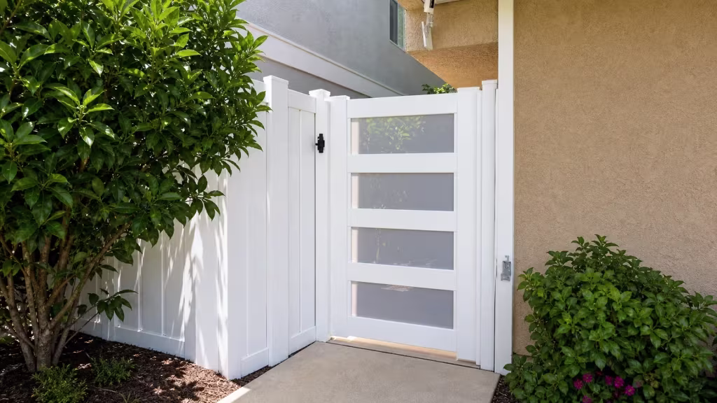 Four frosted acrylic openings fill this White vinyl side gate installed beside a beige stucco house wall