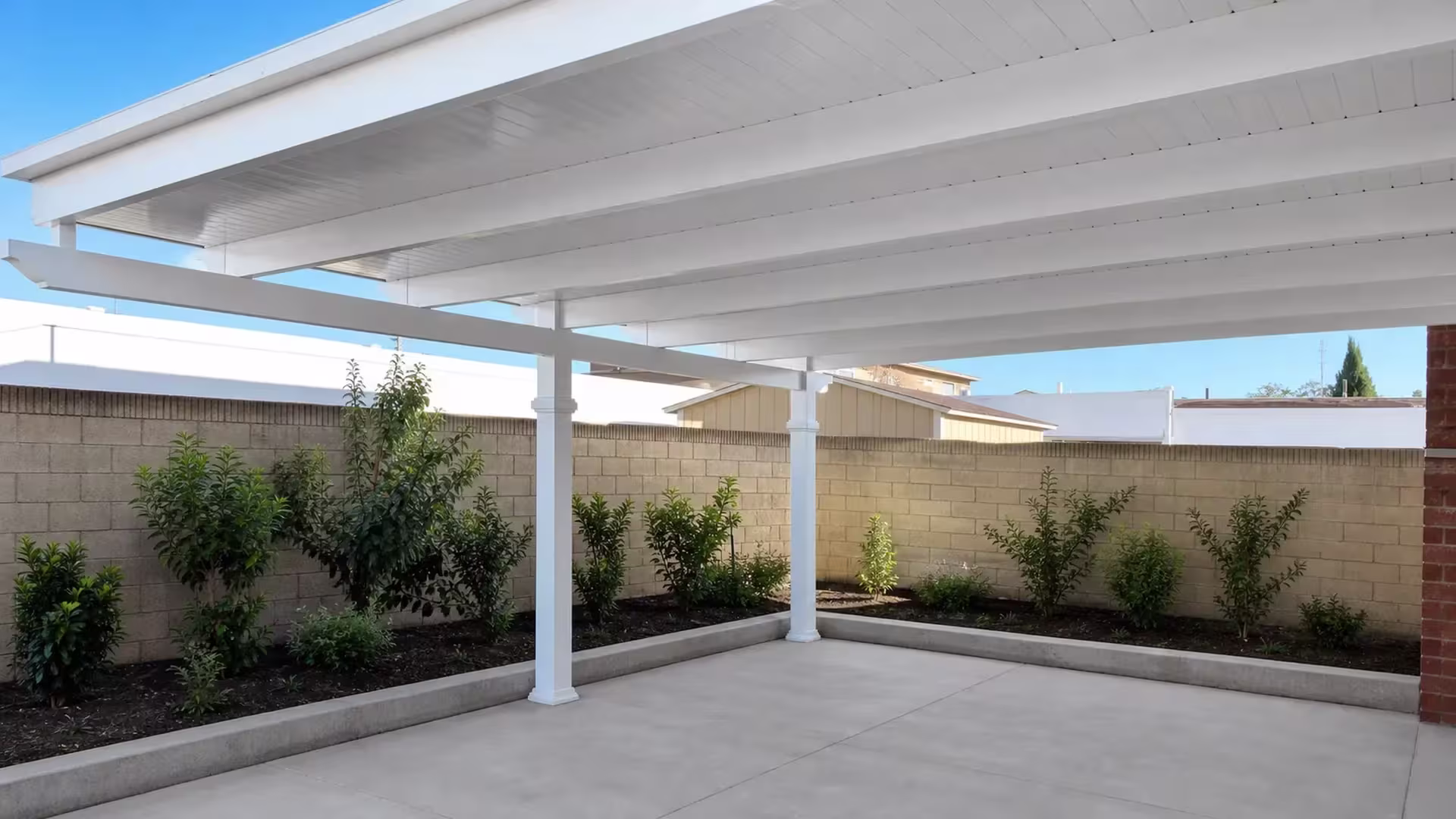 Planting beds edge the masonry boundary walls that circle this White vinyl cover fixed overhead in the yard