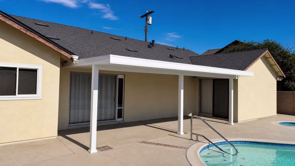 A stainless steel handrail follows the pool coping under the vinyl cover mounted on beige stucco siding