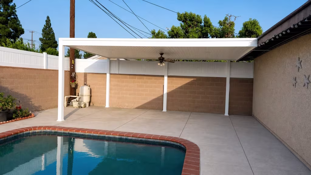A centered ceiling fan hangs from the White vinyl cover above masonry walls topped with matching White fencing