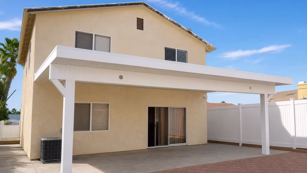 Patterned foreground pavers lead toward the White vinyl cover fixed on a two story beige stucco exterior