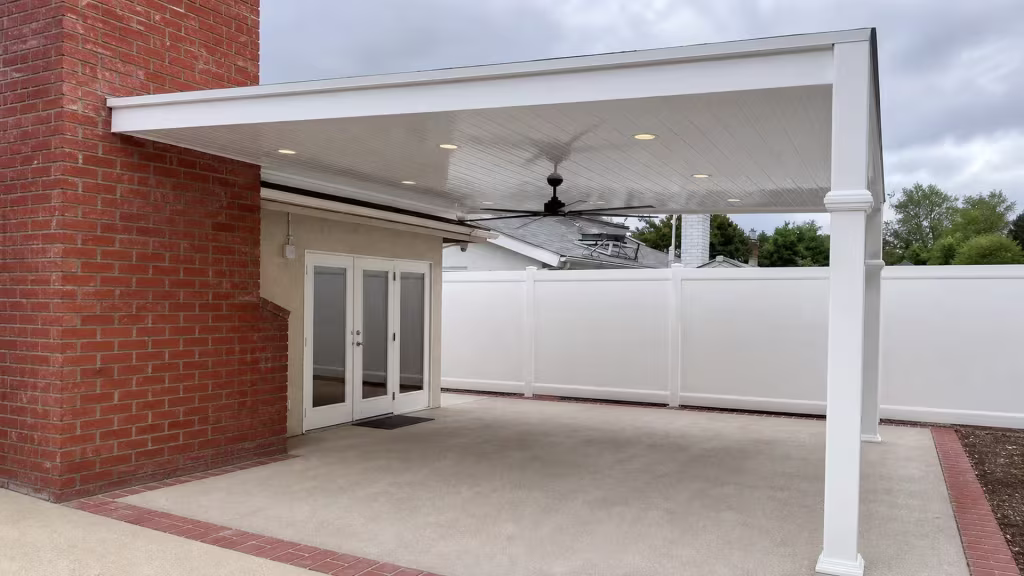Double French doors open near the White vinyl cover mounted on a brick and stucco house wall