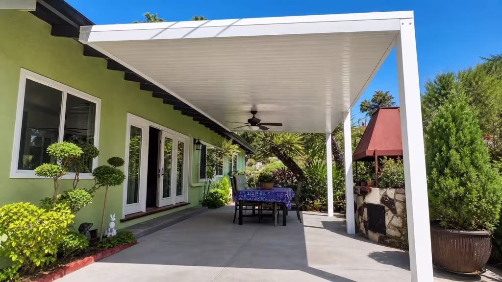 Ribbed vinyl panels form the roof of a White cover fixed along a pale green stucco exterior wall