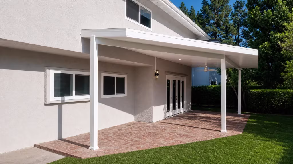 A long rectangular White vinyl solid patio cover projects from the rear wall of a two story stucco house