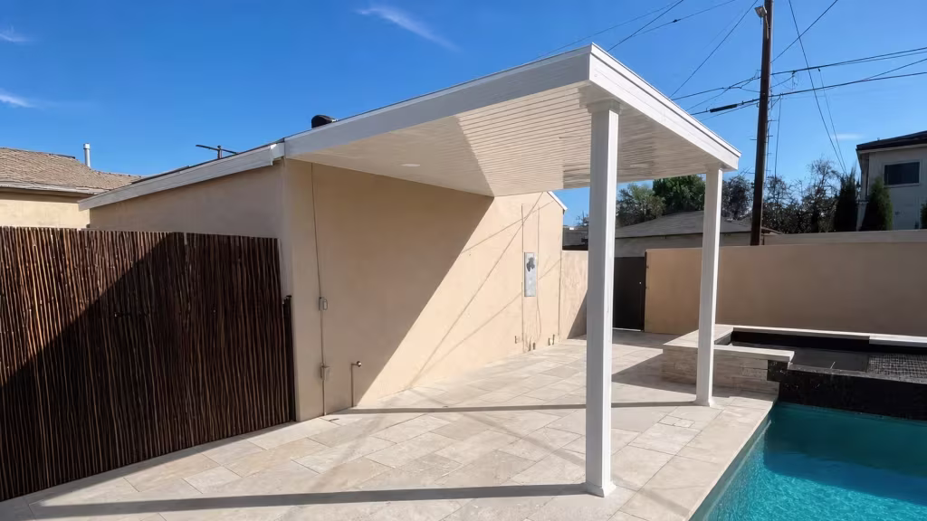 An overhead utility line crosses near the White vinyl cover that shades the deck beside the swimming pool