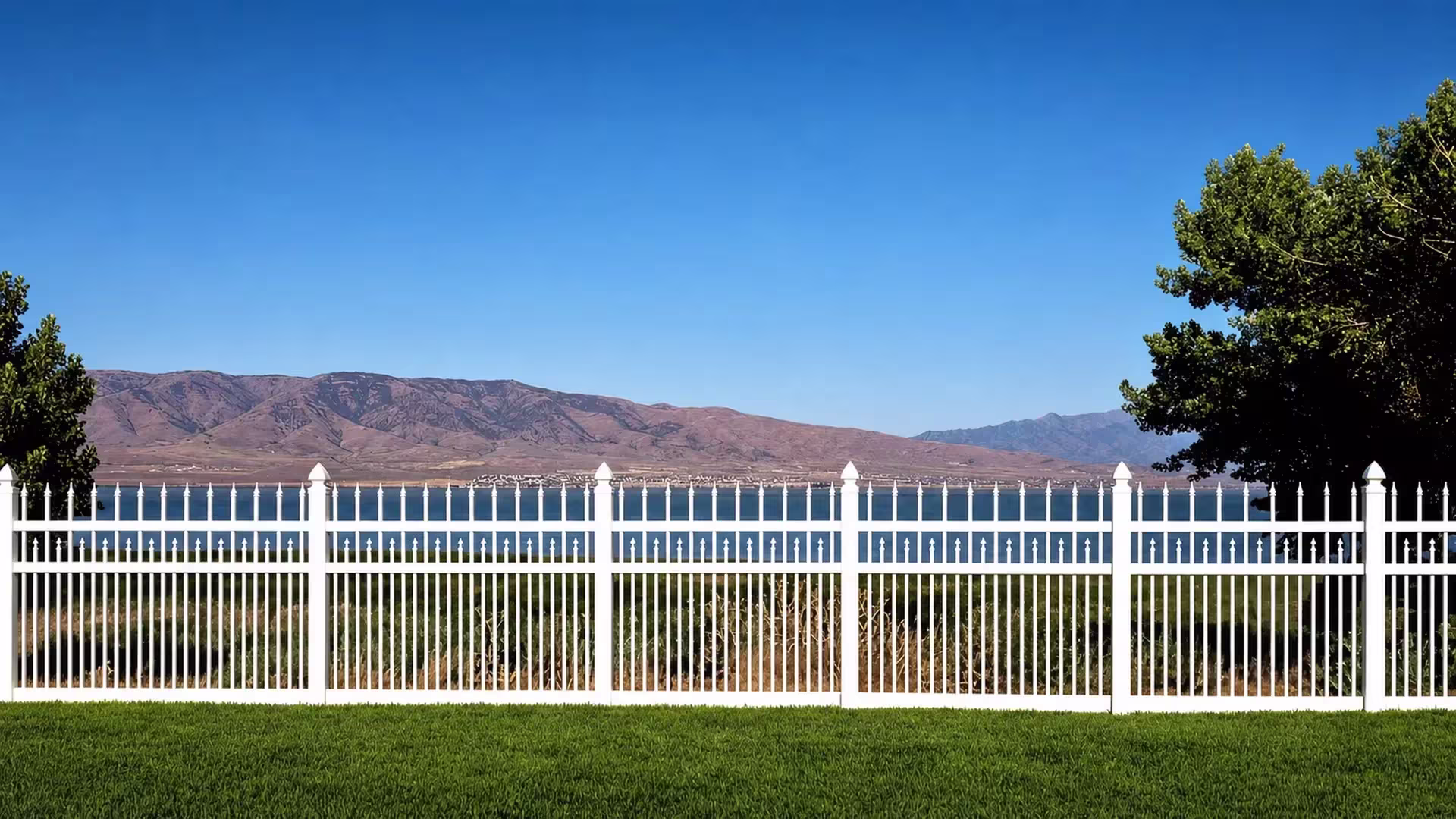 Three stacked bands of White vinyl pickets rise to different heights between the fence horizontal rails