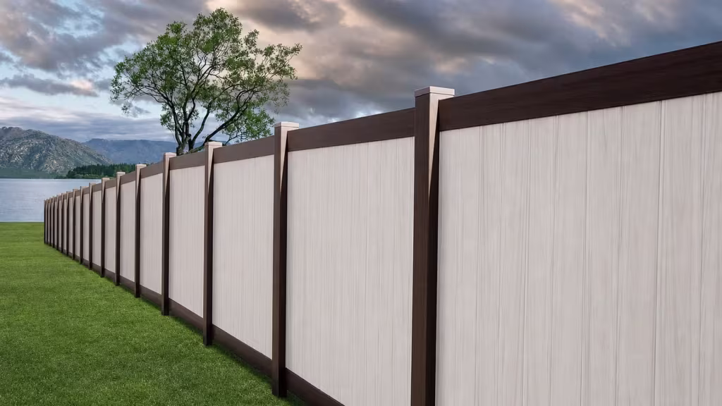 White vinyl two-tone fence descending in a straight run beside a sloped lawn