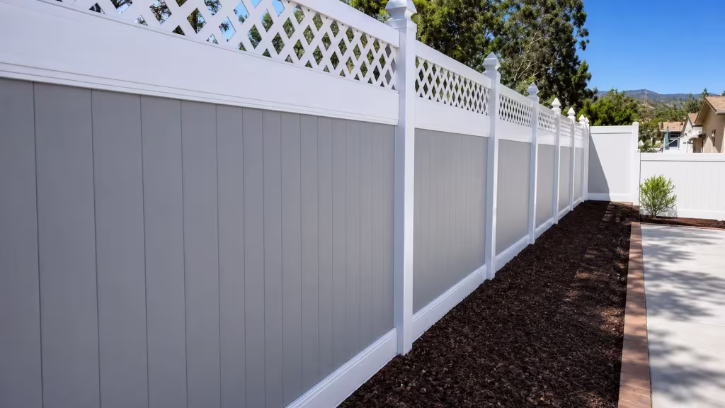 White vinyl two-tone fence topped with a diamond lattice section above a brick patio