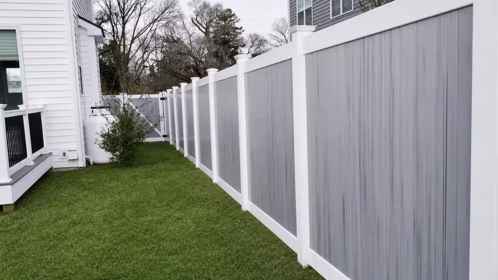 Two houses frame the White vinyl two-tone fence filling the narrow side yard